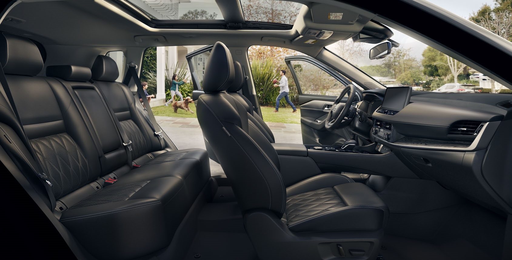 2026 Nissan Rogue Platinum AWD cabin with Charcoal quilted leather-appointed seating, viewed through the open side doors.