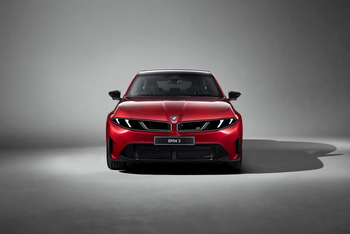 Front view of the red new BMW 3 Series showing its full-width light signature and kidney grille