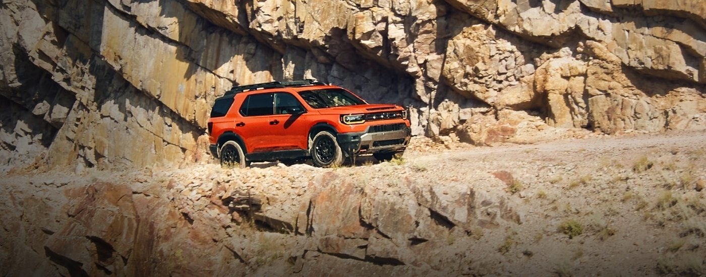Orange 2026 Honda Passport parked on the edge of a cliff