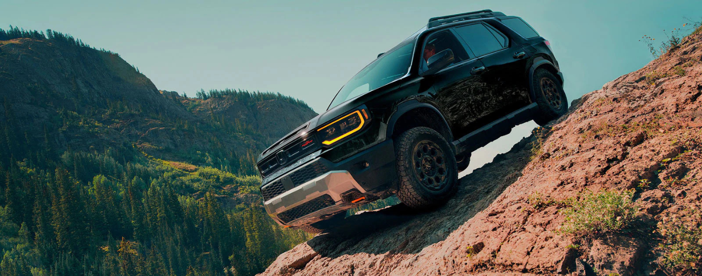 Black 2026 Honda Passport Trail Sport driving down a steep decline