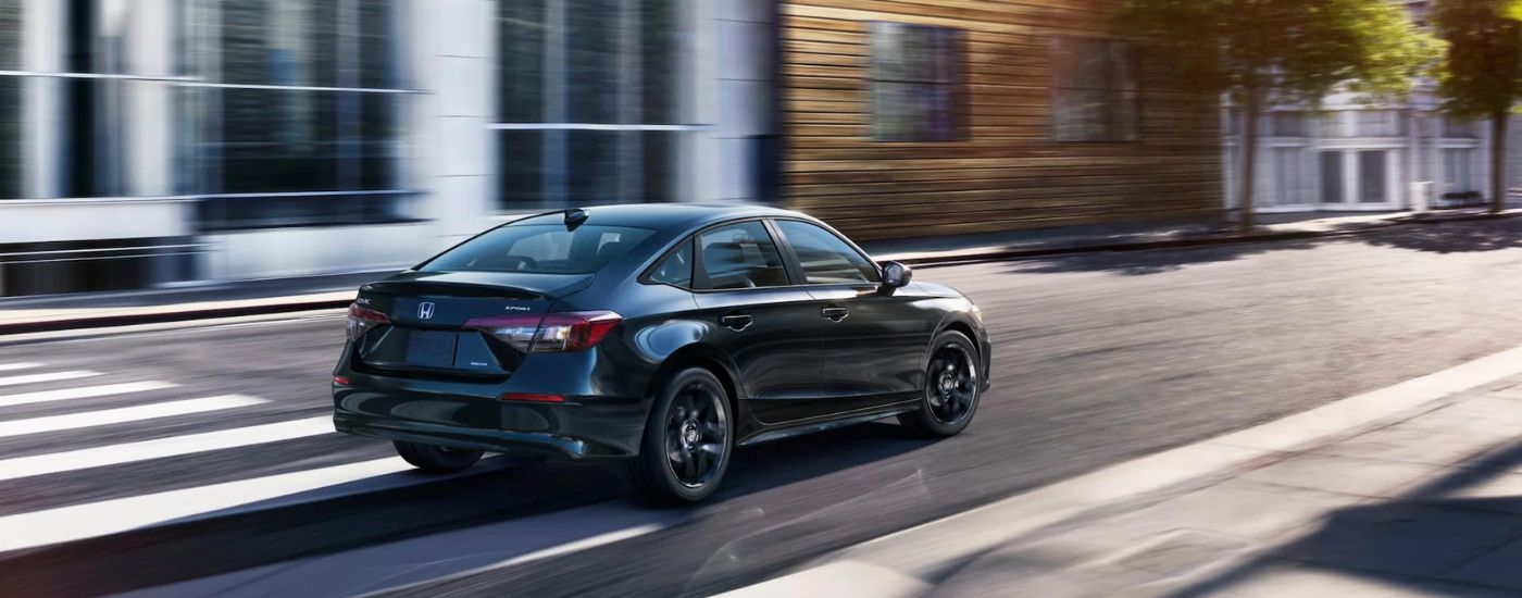 Black 2026 Honda Civic driving through a city from the rear