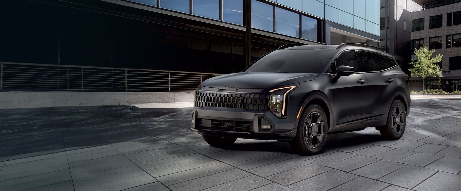 2027 Kia Sportage Plug-In Hybrid X-Line in dark gray parked on a city plaza