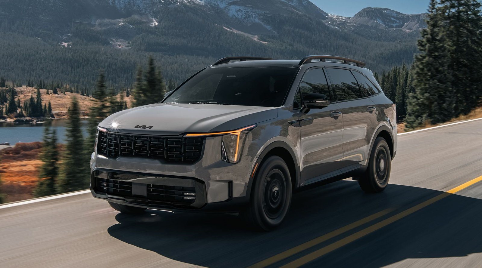 2027 Kia Sorento in gray on a mountain road beside a lake