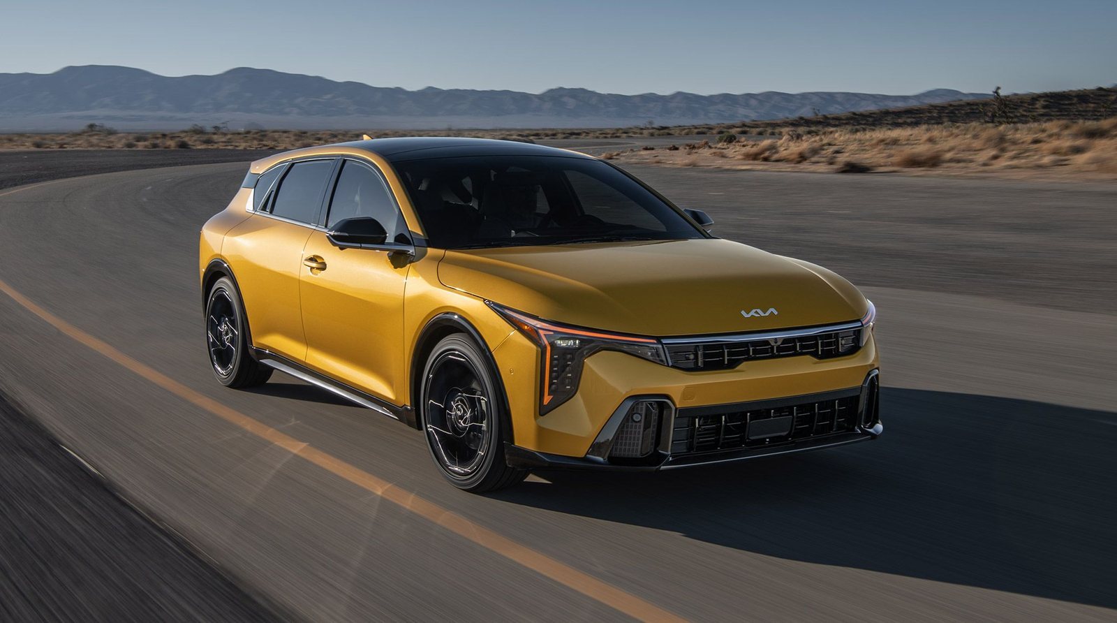 Kia K4 Hatchback in yellow driving on a desert highway