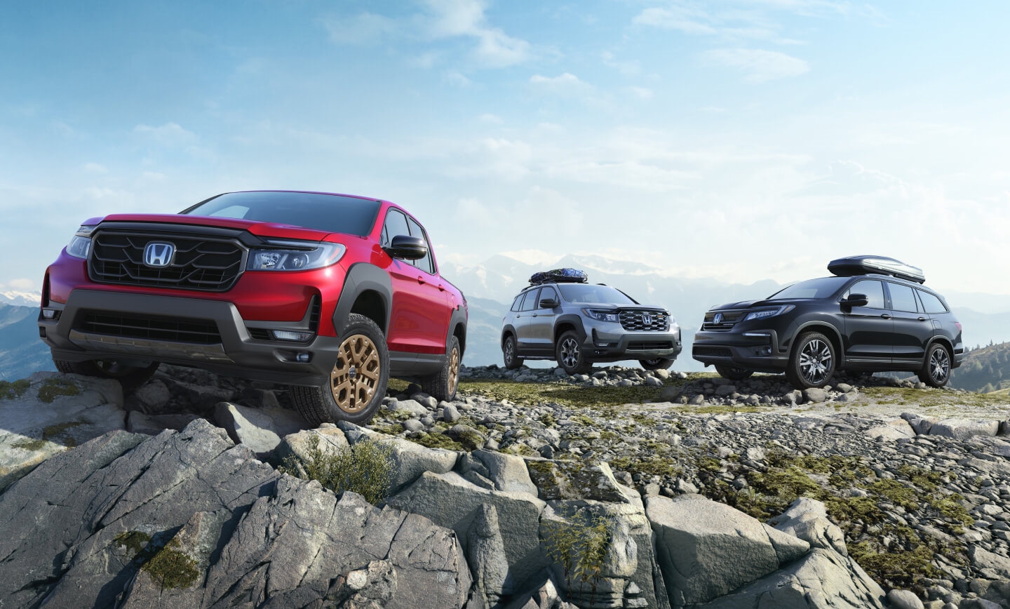 Three 2024 Honda trucks and SUVs parked side-by-side on a rocky mountain clearing.